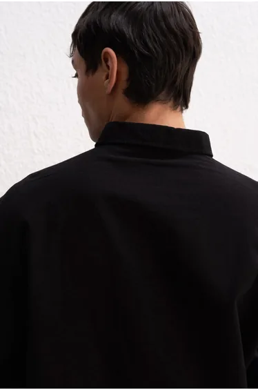 قميص أسود بأكمام طويلة