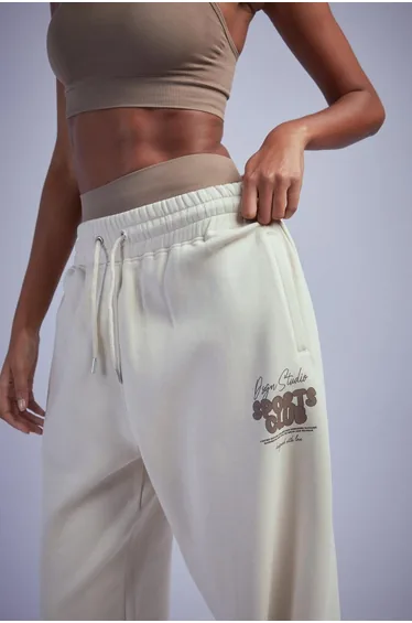 بنطلون رياضي بتصميم واسع بحواف ضيقة بطبعة شعار بشعار - بيج
